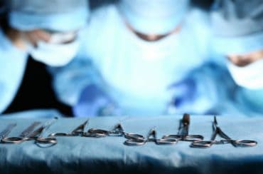 כירורגים בזמן ניתוח על רקע שולחן כלי ניתוח